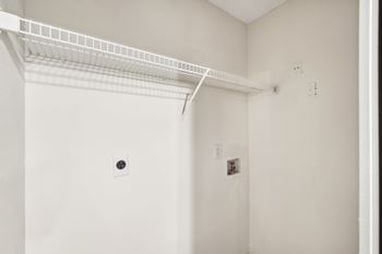 A white wall with a white shelf on it.